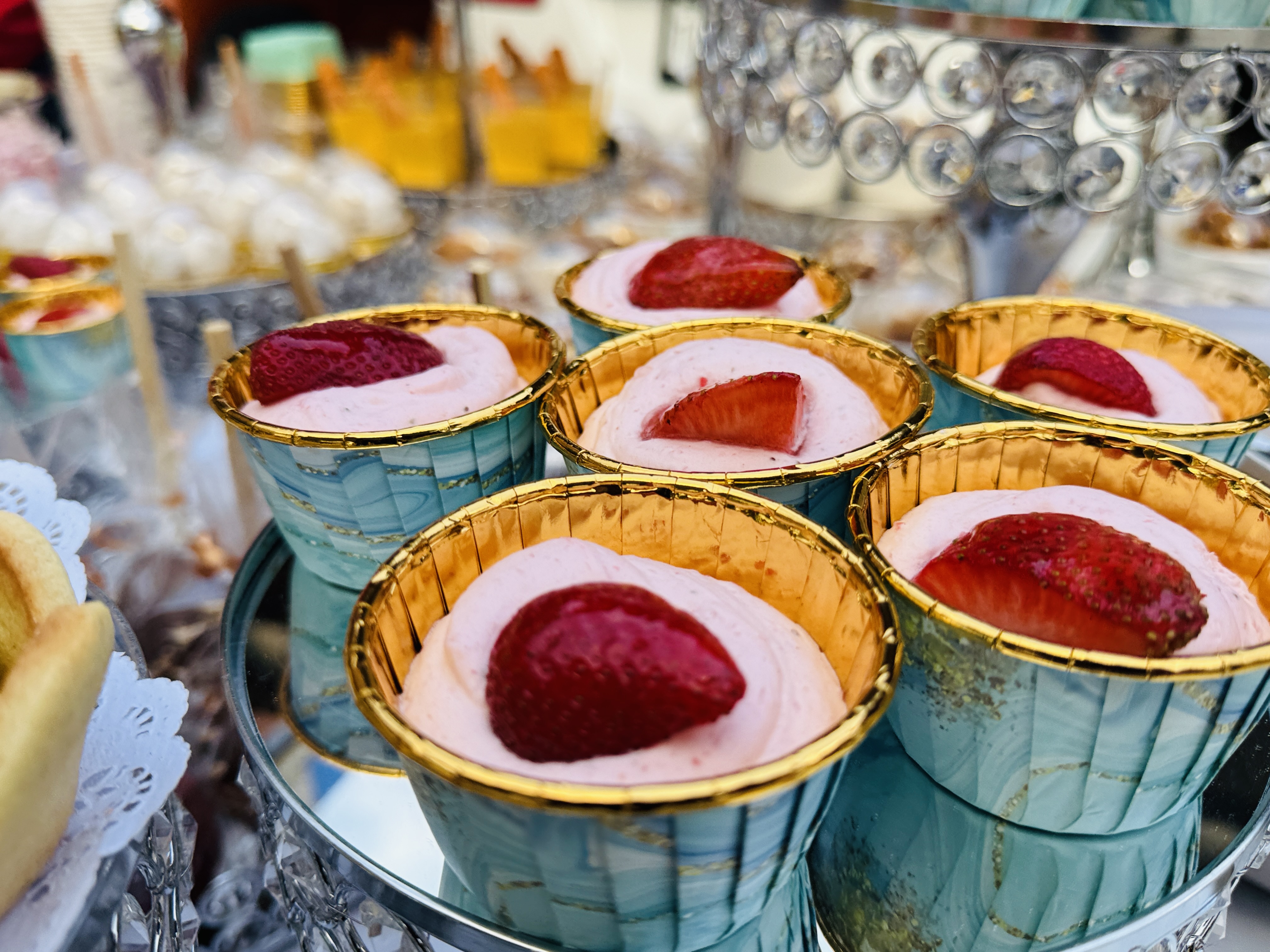 Mesa de postres con copas de mousse de fresa